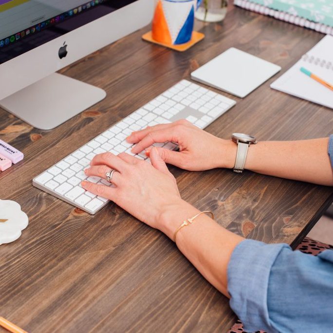 Woman sat at desk typing on keyboard
