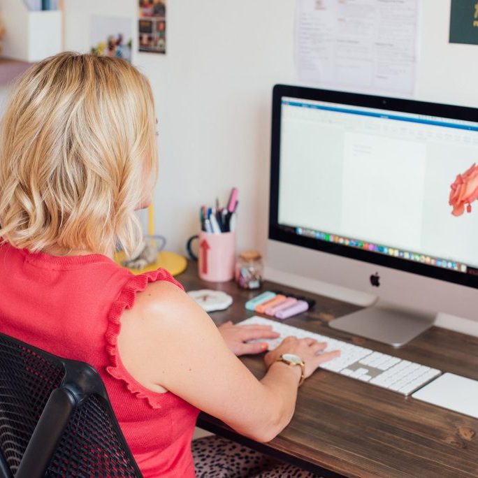 Kellie sat on computer working on Asana