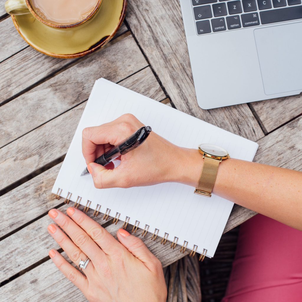 Virtual Assistant holding a pen writing in a notebook