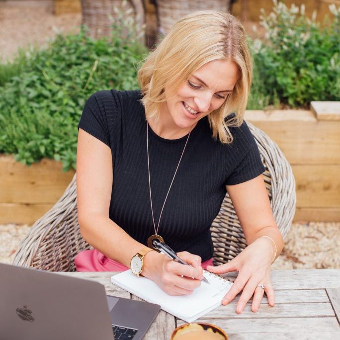 Kellie sat at table writing in notebook - keeping track of key dates