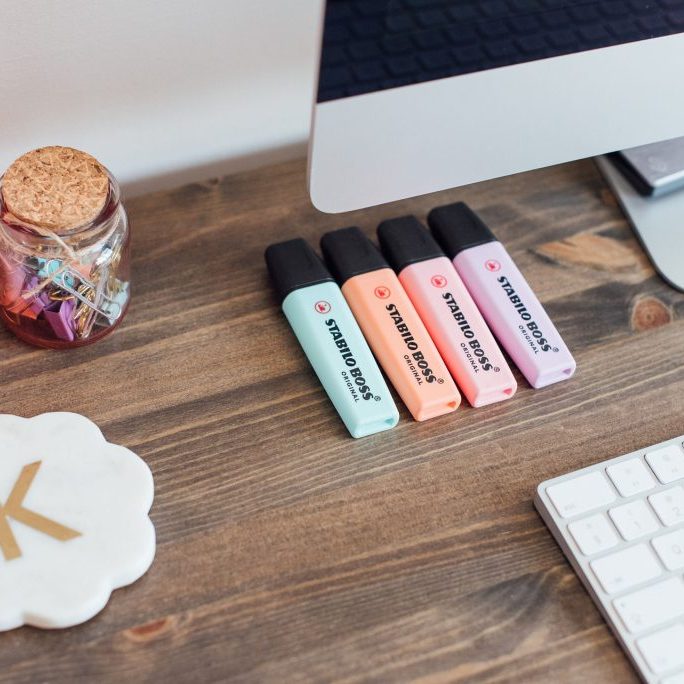 Desk with highlighter pens, coaster, keyboard and Mug