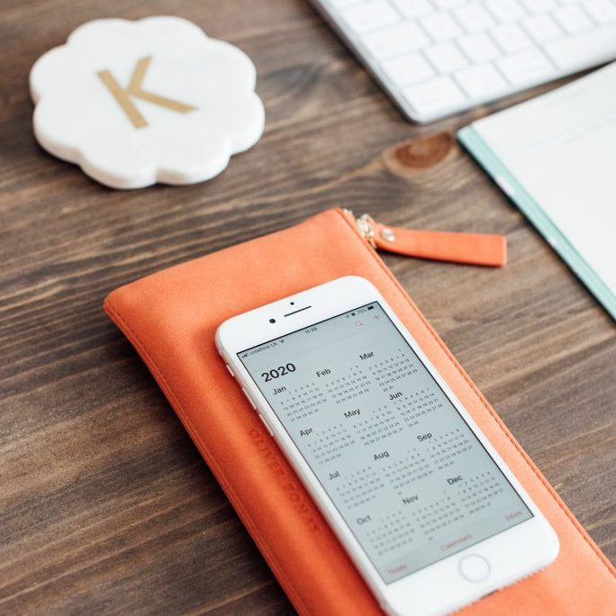Desk with iphone showing 2020 calendar and daily planner